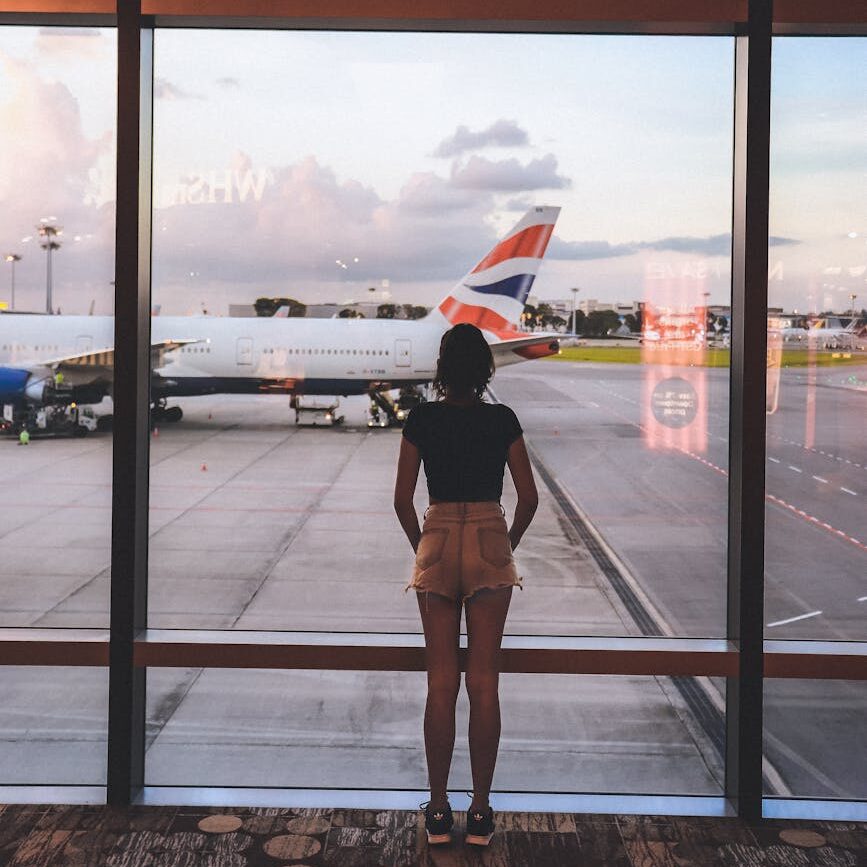 photo of woman standing near glass wall
